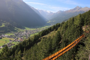 The suspension bridge on the Sunnenseit'n Weg with a view over Neustift in the Stubaital.