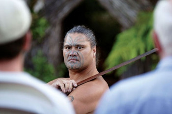 Maori guard standing at the entrance of the village