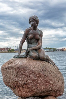 The Little Mermaid on the reddish stone at Copenhagen&#39;s port entrance