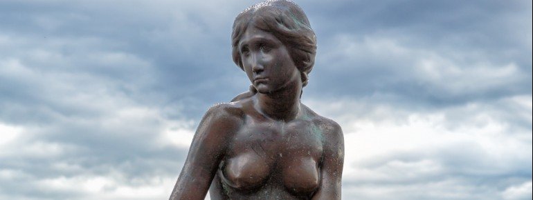 The Little Mermaid on the reddish stone at Copenhagen&#39;s port entrance