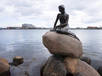 The Little Mermaid in front of Copenhagen&#39;s port scenery