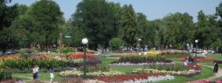People enjoying Washington Park during the summer. In the background: Its colorful flowerbeds.