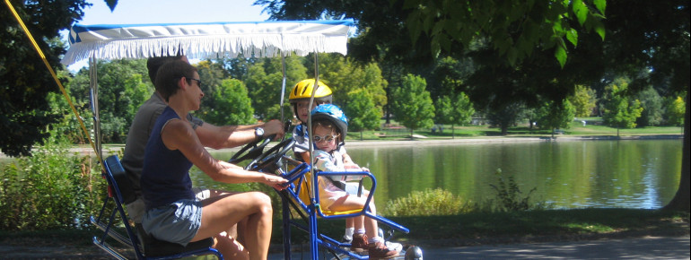 Family rides in a bicycle cart at Washington Park.