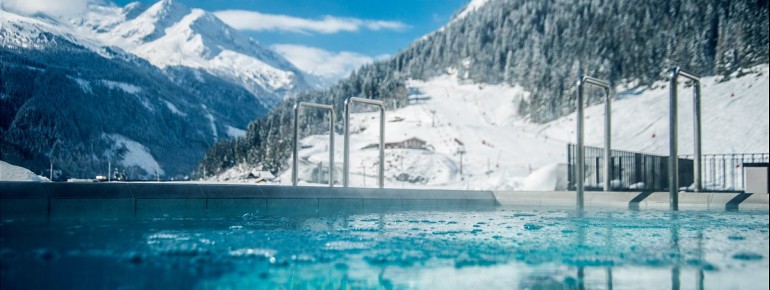 Ein Highlight in der kalten Jahreszeit: der ganzjährig beheizte Außenpool mit Blick auf die winterliche Bergwelt.