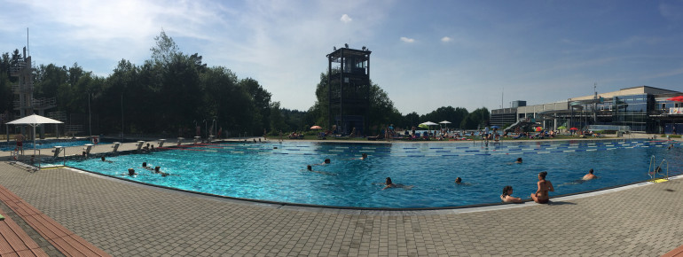 Panoramablick von der Tribüne im PEB auf das Sportbecken, Sprungturm (links), Bademeister-Turm (Mitte), Rutsche, Restaurant und Umkleiden (alles rechts)