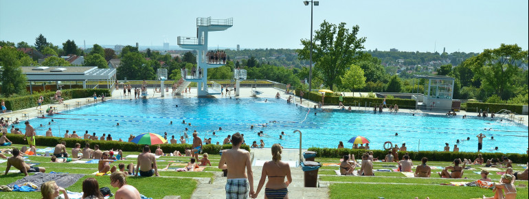 Von der Liegewiese kannst du den Sprungturm und das Sportbecken beobachten.
