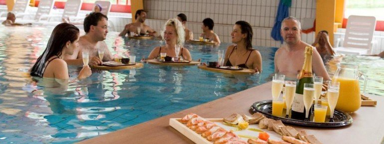 Die Badegäste genießen ein köstliches Frühstück im Thermalwasser.