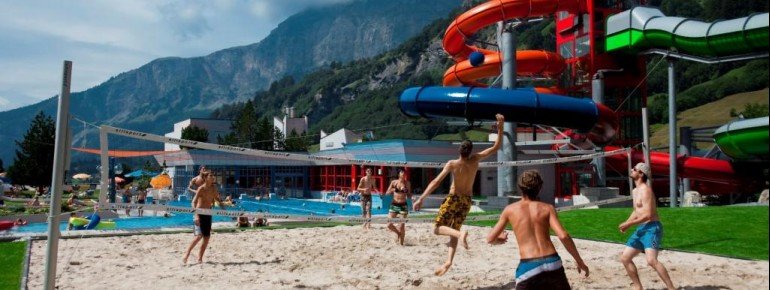Im Sommer wartet ein Beach-Volleyballplatz auf die Besucher. Im Hintergrund sind die xtube Reifenrutsche und die Röhrenrutsche zu sehen.