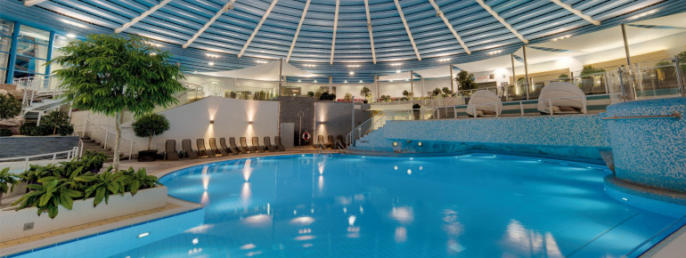 Im großen Erlebnisbecken gibt es Geysire, Sprudelbänke und Massagedüsen. Hinter dem Wasserfall kannst du in der Grotte entspannen.