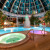 Die Whirlpools und das Erlebnisbecken unter der großen Glaskuppel der Therme