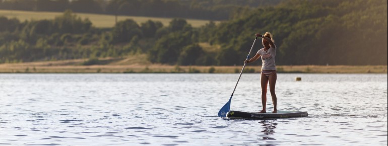 Am See gibt es Verleihstationen für Stand Up Paddle Boards.