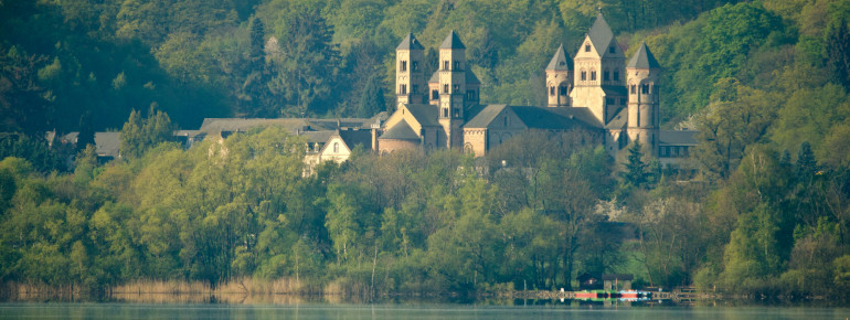 Direkt am See liegt die Benediktinerabtei Maria Laach.