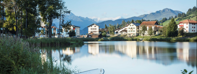 Am Badesee erwartet dich eine große Liegewiese, ein Strand, klares Seewasser und ein einzigartiges Bergpanorama.