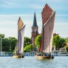 Wustrower Zeesbootregatta: Historische Segelboote mit rotbraunen Segeln gleiten über den Bodden – ein maritimes Traditionsevent im Sommer.