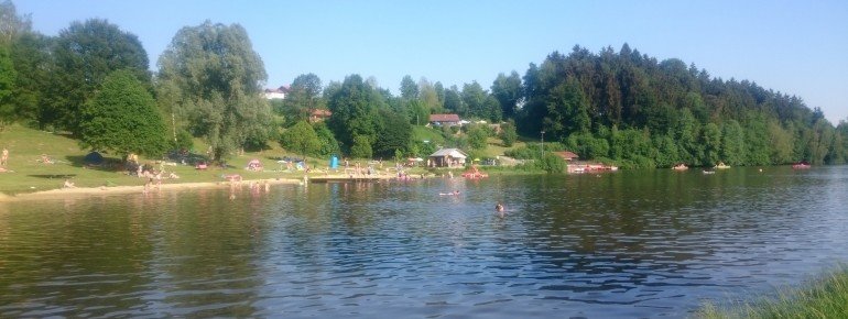 Gegenansicht der Liegewiese mit dem Tretbootverleih und dem großen Spielplatz
