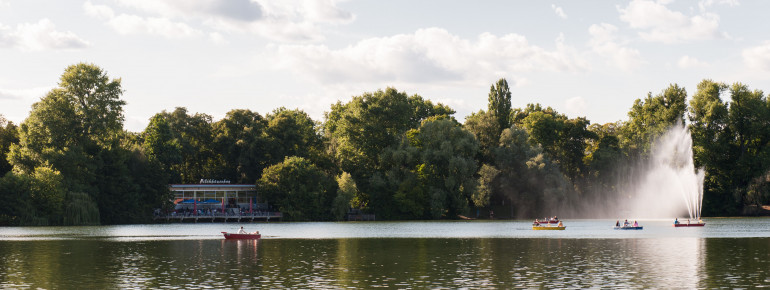 Der Weissensee ist bekannt für die zahlreichen Ruderboote, die darauf fahren. Die Verleihstation befindet sich direkt am Strandbad. Im Hintergrund ist das historische Milchhäuschen zu sehen.