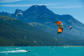Kitesurfing in front of a beautiful Alpine panorama.