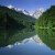 The mountain-scape is reflected by the clear lake water.